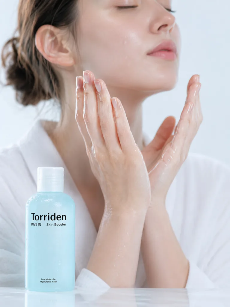 Close-up of hands applying a clear hyaluronic acid Korean essence to relieve tight, flaky sensitive skin