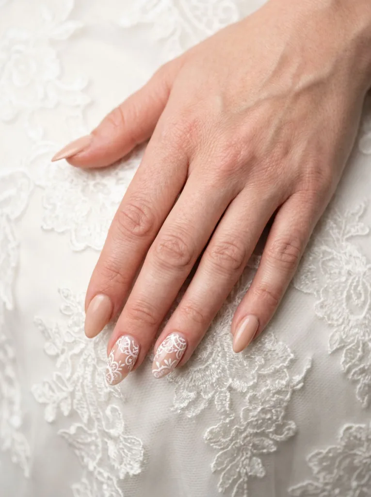Lace-inspired wedding nail art resting against lace gown fabric detail