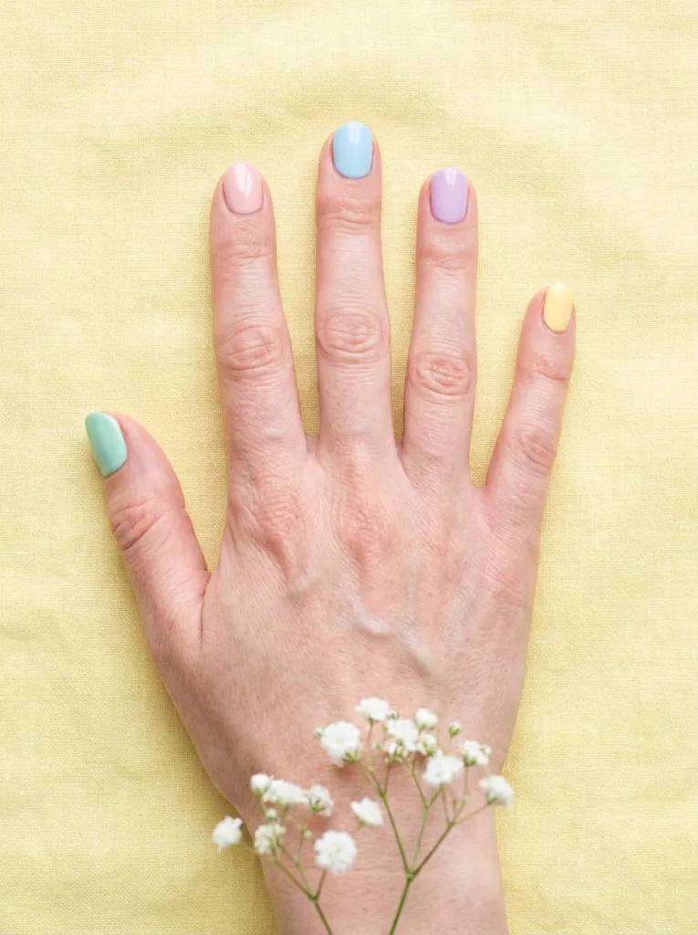 Pastel skittle easter nails in mint pink blue lilac and yellow on linen tablecloth