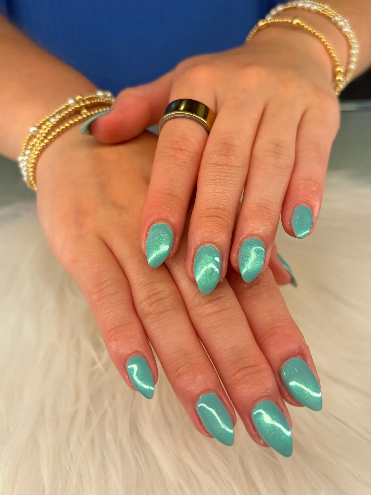 Glossy turquoise-teal almond nails with fine reflective shimmer