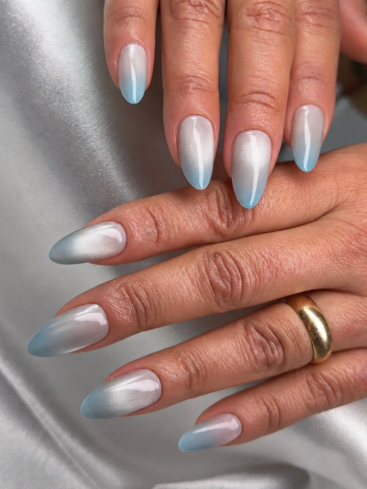 Milky white almond nails fading into pale blue tips