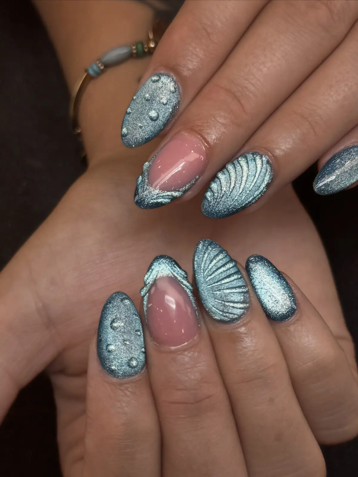 Metallic blue-silver nails with shell textures, clear droplets and nude French accents