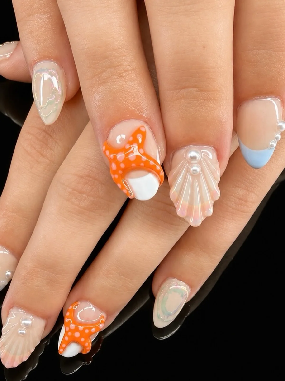Pale blue French nails with raised orange starfish and translucent shells