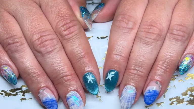 Mermaid nails with teal starfish accents, blue waves, 3D shells and glitter on two hands