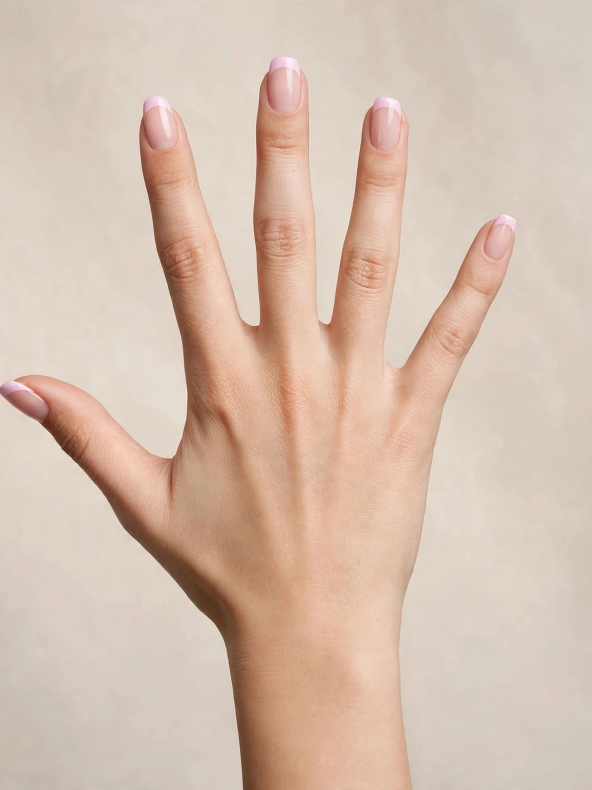 French manicure with pastel baby-pink tips on a sheer nude base